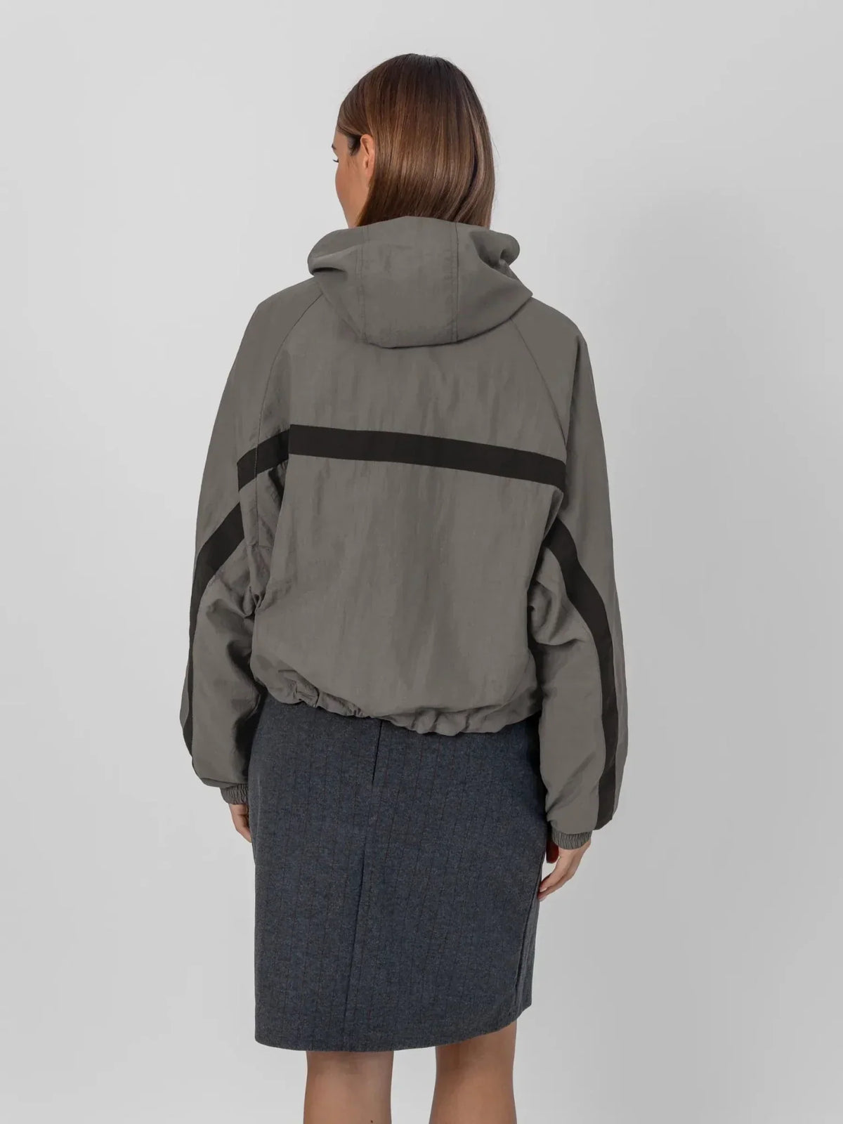 Back view of a PUFFLT water repellent oversized short track jacket in grey with black stripes.